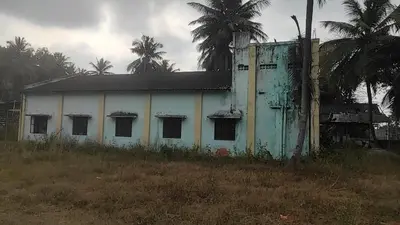 an old white building in a field with palm trees at NKM Holiday Park in Shrīrangapattana
