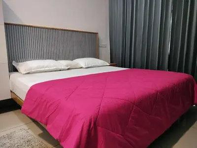 a bedroom with a large bed with a pink blanket at Little home Apartment 1 in Tāzhekkod