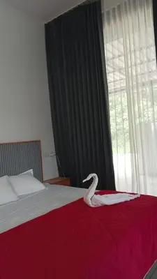 a white swan sitting on a bed in a bedroom at Little home Apartment 1 in Tāzhekkod