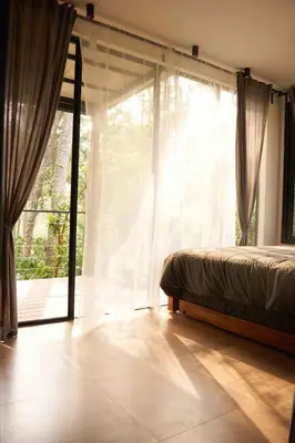 a bedroom with a bed and a large window at Trumpet Deck 3BHK Container Home in Kutta