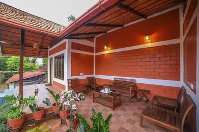a patio with benches and tables on a brick wall at Trumpet Deck 3BHK Container Home in Kutta