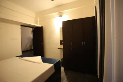 a small bedroom with a bed and a cabinet at Emberlin Holidays in Wayanad