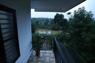 a balcony with a view of a river at Emberlin Holidays in Wayanad