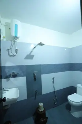 a bathroom with a toilet and a sink at Emberlin Holidays in Wayanad