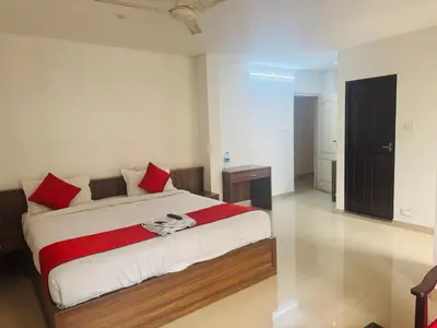 a bedroom with a large bed with red pillows at Moon Way in Neriyamangalam