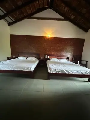 a bedroom with two beds and a wall at Sky Holiday Homestay Cottages Madikeri Kushalnagar Coorg in Kushālnagar