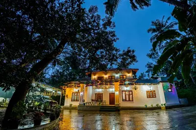 a house with lights on top of it at night at vintage inn in Kommeri