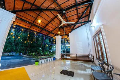 a large room with a wooden ceiling and a staircase at vintage inn in Kommeri
