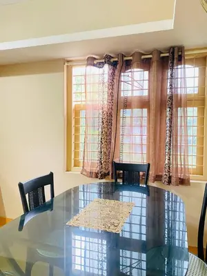a dining room with a glass table and two chairs at Verito Home Stay