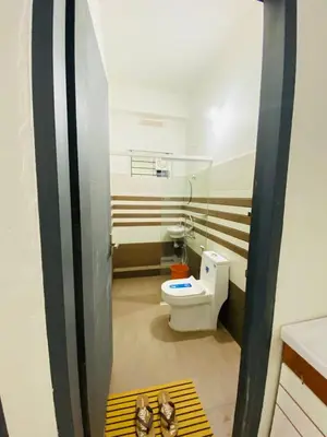 a bathroom with a toilet and a pair of shoes at Verito Home Stay