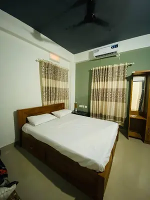 a bedroom with a bed with white sheets and curtains at Verito Home Stay