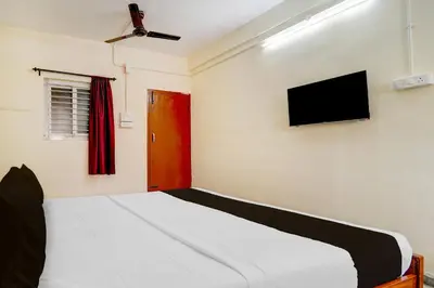 a bedroom with a bed and a flat screen tv at Super Collection O Avarampalayam Bus Stop Formerly Krish Castle in Coimbatore