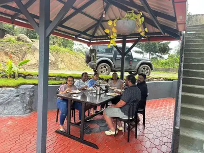 a group of people sitting at a table under a pavilion at Misty huts home stay in Madikeri