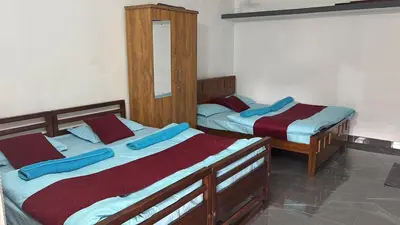 two twin beds in a room with a mirror at Misty huts home stay in Madikeri