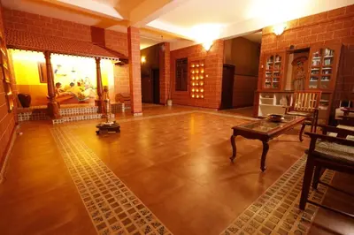 a large room with a wooden floor and a table at FAMILY RESORT MARAYOoR KANTHALLOOR in Kanthalloor