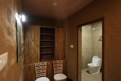 a bathroom with a toilet and a sink and a shower at Papilio Mudhouse Stay in Edayūr