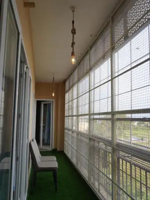 a room with a chair and large windows at Pearl Home Luxury 3Bhk family-friendly Appartment in Mysore
