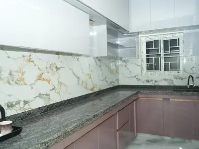 a kitchen with marble counter tops and a window at Serene Legacy in Mysore