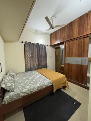 a bedroom with a bed and a ceiling fan at Sihi-2 bhk Non AC and Penthouse AC Rooms in Mysore