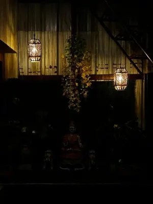 a dark room with two lights and a plant at Sihi-2 bhk Non AC and Penthouse AC Rooms in Mysore