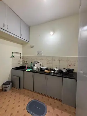 a kitchen with a counter top with pots and pans at Sihi-2 bhk Non AC and Penthouse AC Rooms in Mysore