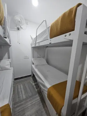 a small room with two bunk beds in it at Lowfare Dormitory in Kozhikode