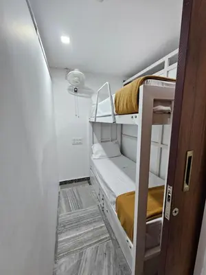 a hallway with bunk beds in a room at Lowfare Dormitory in Kozhikode