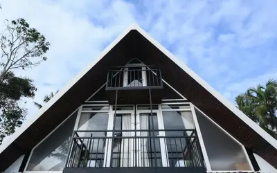 a pyramid shaped house with glass windows on top of it at Vadanapilly Beach Villa for 8-10 adults in Irimbranallūr