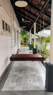 a porch with a rug on the floor of a house at Private 1BHK Kerala Village Homestay with Open Veranda near Thrissur in Cheruthuruthi