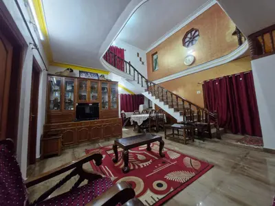 a living room with a staircase and a dining room at Coorg Coffee Tales in Suntikoppa