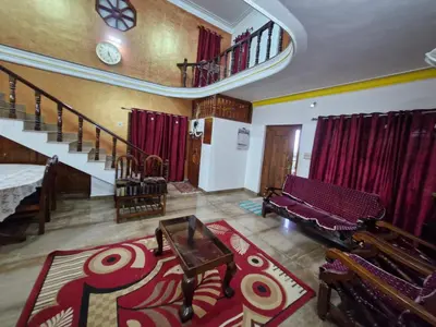 a large living room with a table and a staircase at Coorg Coffee Tales in Suntikoppa