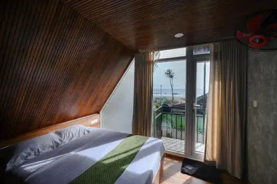 a bedroom with a bed and a large window at Heaven-Vadanapilly Beach Villa in Irimbranallūr