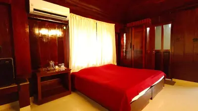 a bedroom with a red bed and a window at Cherai Beach Regency in Ernakulam