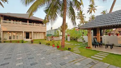 a courtyard with palm trees and a building at Cherai Beach Regency in Ernakulam