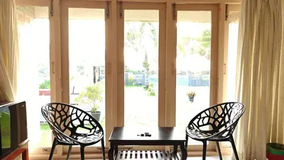 two chairs and a table in front of a window at Cherai Beach Regency in Ernakulam