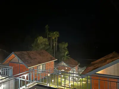 a group of houses with lights on them at night at Misty Slope in Panamaram