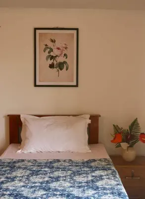 a bedroom with a bed with a picture on the wall at Fairwinds Coorg - Boutique Homestay at Coffee Farm in Virajpet