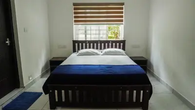 a bed in a room with a window at Panakkal Homes in Guruvāyūr