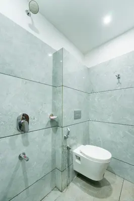 a bathroom with a toilet and a glass shower at Hotel faaz international in Thottada