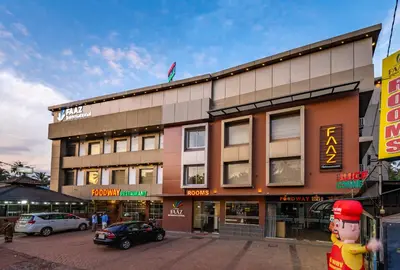 a building on a street with cars parked in front of it at Hotel faaz international in Thottada
