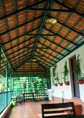 a room with benches and a wooden ceiling at Paddy Land in Wayanad