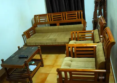 a living room with a couch and chairs and a table at Paddy Land in Wayanad