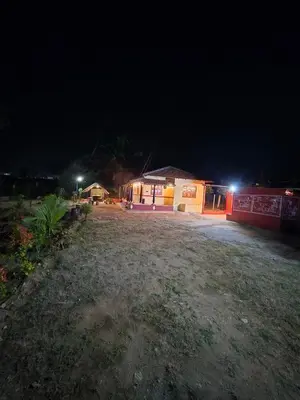 a night view of a building with lights in the background at Namma Hatti, Traditional Home in Chattanahalli