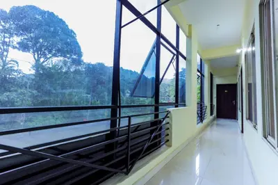 a room with large windows with a view of the forest at Igloo Residency in Vythiri