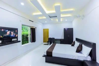 a bedroom with a bed and a flat screen tv at Igloo Residency in Vythiri