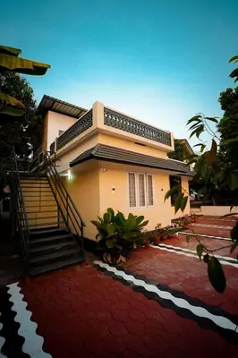 a house with a staircase in front of it at Cozy Nest Villa in Mananthavady