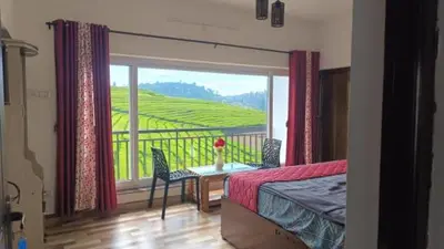 a bedroom with a bed and a balcony with a view at Tea Garden stays in Ooty