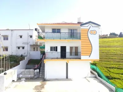 a house with a balcony on the side of it at Tea Garden stays in Ooty