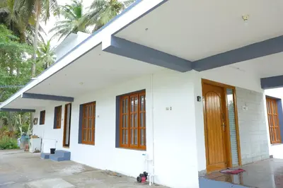 a white house with wooden doors and windows at 2Bhk White House Near Isha By Shivalaya Stays in Coimbatore