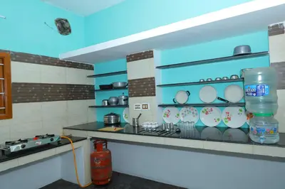a kitchen with a counter with plates on the shelves at 2Bhk White House Near Isha By Shivalaya Stays in Coimbatore